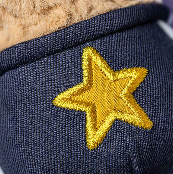 Close-up of the yellow star patch and stitching on Peanut Star Student Outfit’s navy fabric.