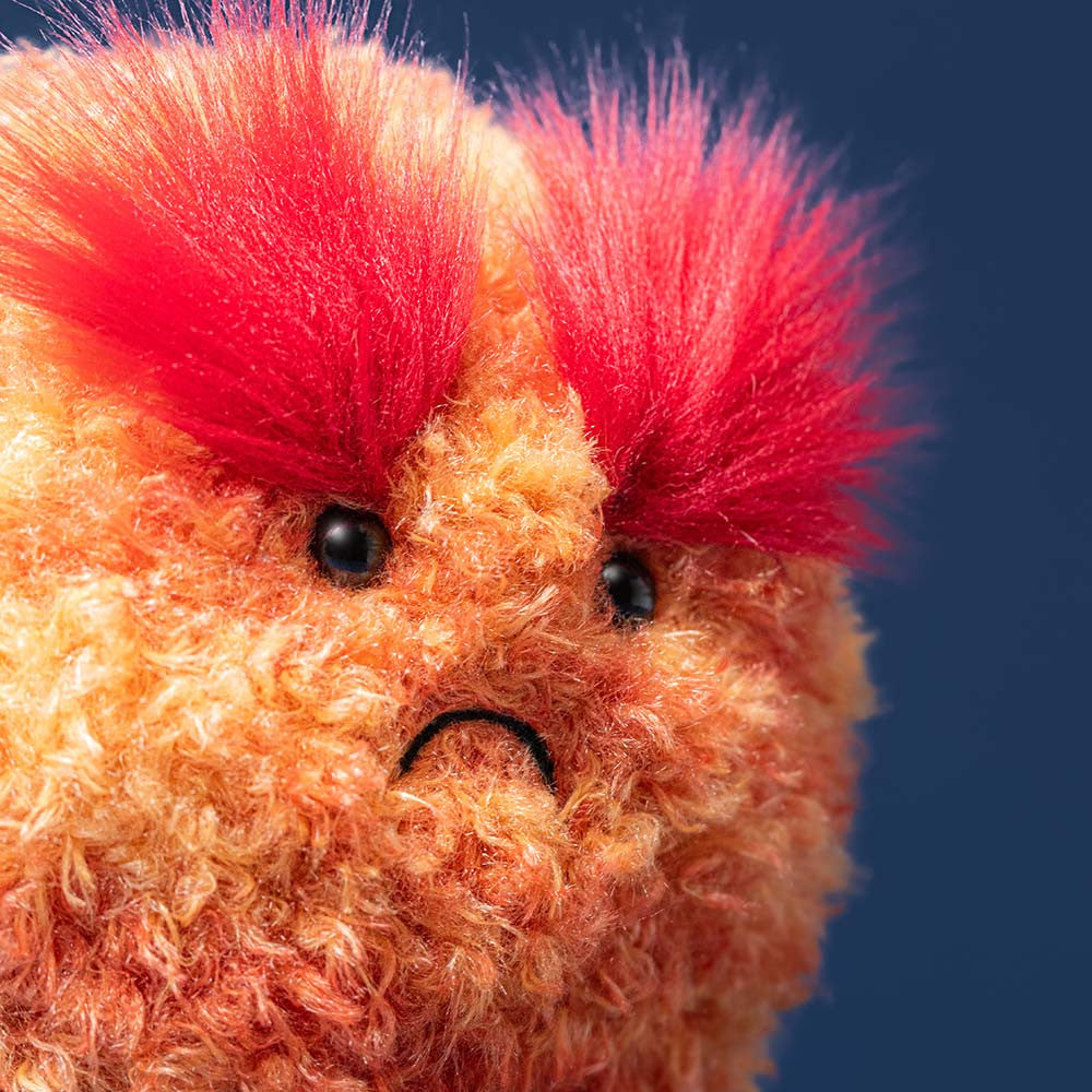 Close-up of Planet Mars showing fluffy red eyebrows, black eyes and a stitched frown against a dark blue background.